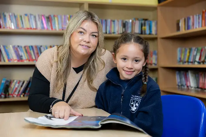 A Level 5 Specialist Teaching Assistant working with a small group of children in a classroom.